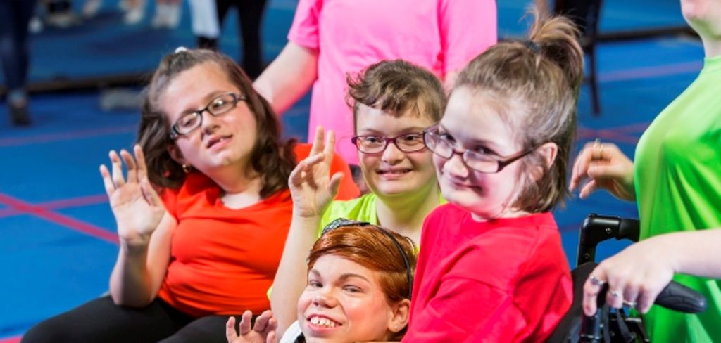 Group of special needs girls in gym exercise class