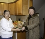 Meals on Wheels client Joan Atkinson (left) receives a delivery from volunteer Barbara Hartford