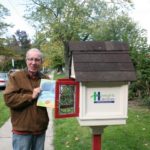 Heights Libraries volunteer John Jarvey stocks the Princeton Road Little Free Library. [photo: Sam Lapides]